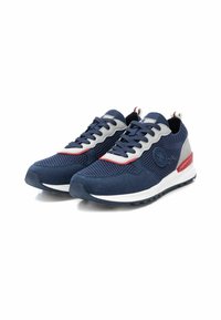 Zapatillas azul marino con materiales de malla y gamuza, con acentos en rojo y gris, suela texturizada y un detalle de logo en el lateral.