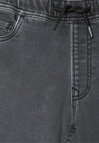 Pantalones de mezclilla gris con cinturilla elástica, cordón y bolsillos laterales. Textura suave con detalles de costura sutiles.
