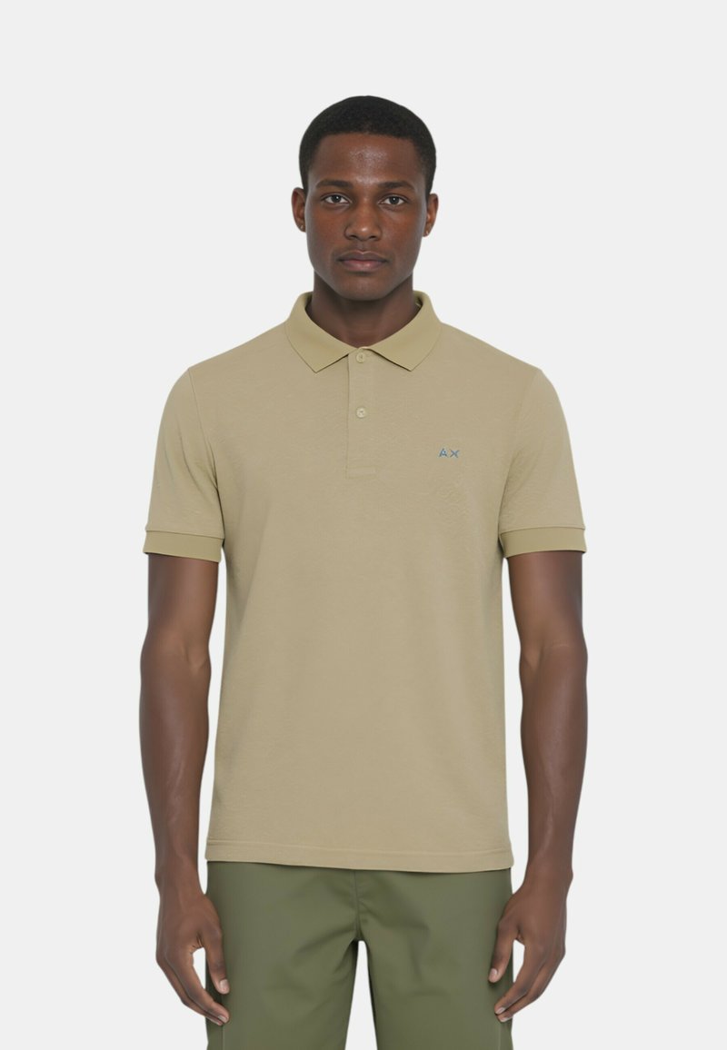 Polo beige con colletto, maniche corte e un piccolo logo blu sul petto; realizzato in cotone morbido.