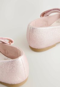 Lyserøde balletflade sko med en tekstureret, metallisk finish, afrundet bagside, blød inderside og fleksibel sål. Justerbar rem for sikker pasform.