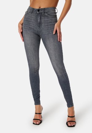 Jean skinny taille haute en denim gris foncé avec une texture lisse, comportant cinq poches et une fermeture à bouton à l'avant.
