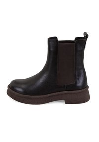 Zwarte leren enklaarsjes met elastische zijpanelen, gestructureerde afwerking en een bruine rubberen zool. Voorzien van een trekband aan de achterkant.