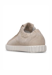 Sneaker in suede beige con una toma superiore testurizzata, apertura elastica e suola in gomma bianca con dettagli rigati. La vista posteriore evidenzia gli accenti di design.
