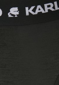 Svart stickade leggings med en mjuk textur och ett elastiskt midjeband med vit logotyp. Midjebandet har en logotypdesign.