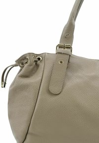 Sac à main en cuir gris texturé avec bandoulière ajustable, quincaillerie en métal et fermeture à cordon. Finition lisse avec une structure souple.