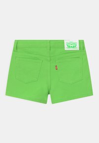 Klart gröna jeansshorts med en slät yta, två bakfickor och en vit Levi's-etikett på midjan.