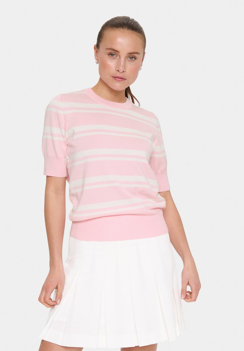 Suéter de manga corta color rosa claro con rayas blancas, cuello y dobladillo acanalados, combinado con una falda blanca con pliegues. Textura de punto suave.