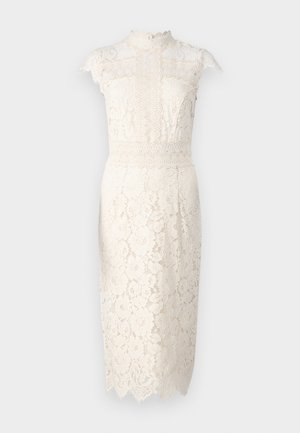 Krém színű csipke ruha, magas nyakkal, rövid ujjal, virágmintákkal és fodros szegéllyel. Közepes hosszúságú, testhezálló szabással.