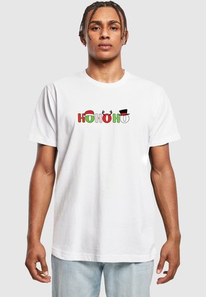 Hvid bomulds t-shirt med "HO HO HO" i rød, grøn og sort, med festlige detaljer såsom en julesok og rensdyrhorn.
