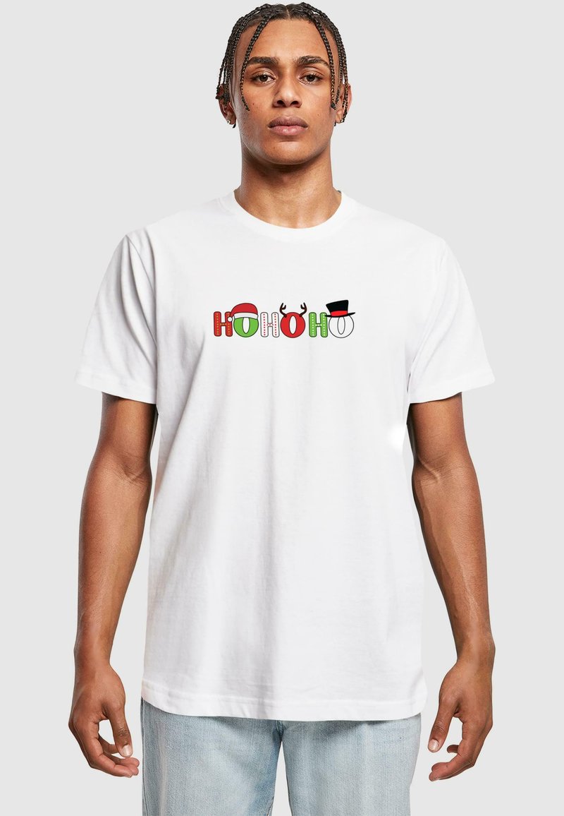 Hvid bomulds t-shirt med "HO HO HO" i rød, grøn og sort, med festlige detaljer såsom en julesok og rensdyrhorn.