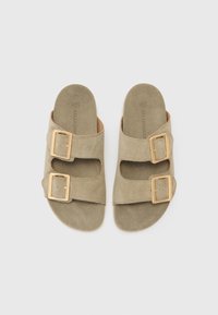 Light olive green suede slide sandals feature two adjustable gold buckles, open toe, and a contoured footbed for comfort.