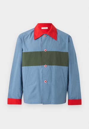 Blaue Jacke mit rotem Kragen und Manschetten, olivgrünem horizontalem Streifen über der Brust und vier rosa Knöpfen vorne.