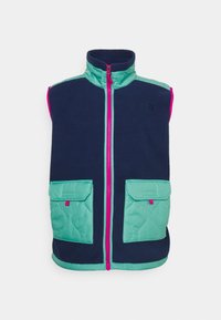 Ärmellose marineblaue Fleece-Weste mit teal-farbenen, gesteppten Akzenten, rosa Reißverschluss und Taschen. Das Design umfasst einen hohen Kragen und ein Logodetail.