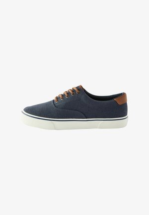 Sneaker in tela blu con dettagli in pelle marrone, punta rotonda, superficie testurizzata, suola in gomma bianca e sei occhielli marroni per i lacci.