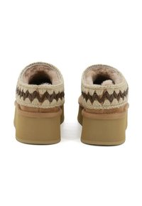 Pantofole beige con un morbido rivestimento interno, caratterizzate da dettagli intrecciati marroni e una suola beige chunky, con un design a retro arrotondato.