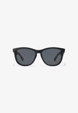 Gafas de sol negras con un marco texturizado y lentes oscuros, con forma de ojo de gato y un sutil logo en las patillas.