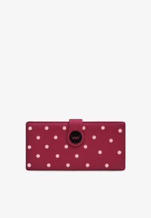 Pink leather wallet featuring white polka dots and a circular black snap closure with a logo. Rectangular design with smooth texture.