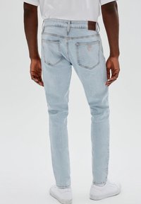Ljust blå jeans i slim fit med bakfickor, en märkesläderlapp vid midjan och en urtvättad finish.