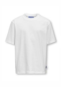 Camiseta blanca de algodón con mangas cortas y cuello redondo. Cuenta con una pequeña etiqueta azul en la costura lateral izquierda. Textura suave, diseño sencillo.