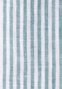 Tissu blanc avec des rayures verticales bleu sarcelle uniformément espacées et une texture tissée visible.