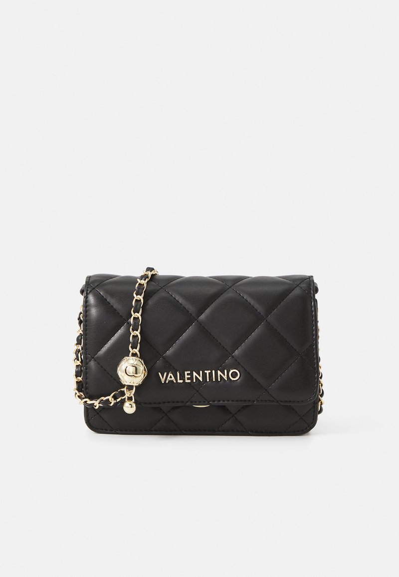 Musta tikattu nahkalaukku kullatulla varustuksella, jossa on ketjuhihna ja VALENTINO-logo edessä. Kompakti ja suorakulmainen muotoilu.