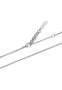 Sølvfarvet armbånd med et delikat kædedesign, en rund lås og et rektangulært mærke indskrevet med "JETTE."