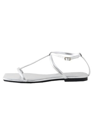 Sandal flat argento con design a T, caratterizzata da una piccola fibbia, forma della punta quadrata e una finitura metallica liscia su una suola nera.