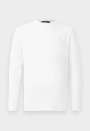 Tricou alb cu mâneci lungi, fabricat din bumbac, având un decolteu rotund și un mic logo brodat pe piept. Textură netedă.
