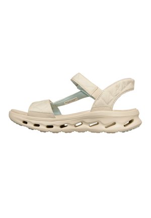 Sandale beige avec coussinet, brides matelassées et semelle ventilée conçue pour le confort et la respirabilité.