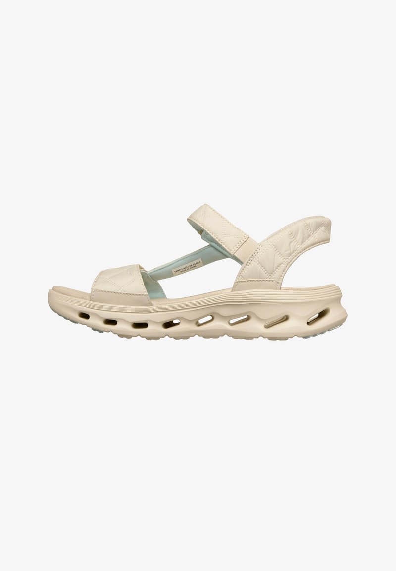 Sandale beige avec coussinet, brides matelassées et semelle ventilée conçue pour le confort et la respirabilité.