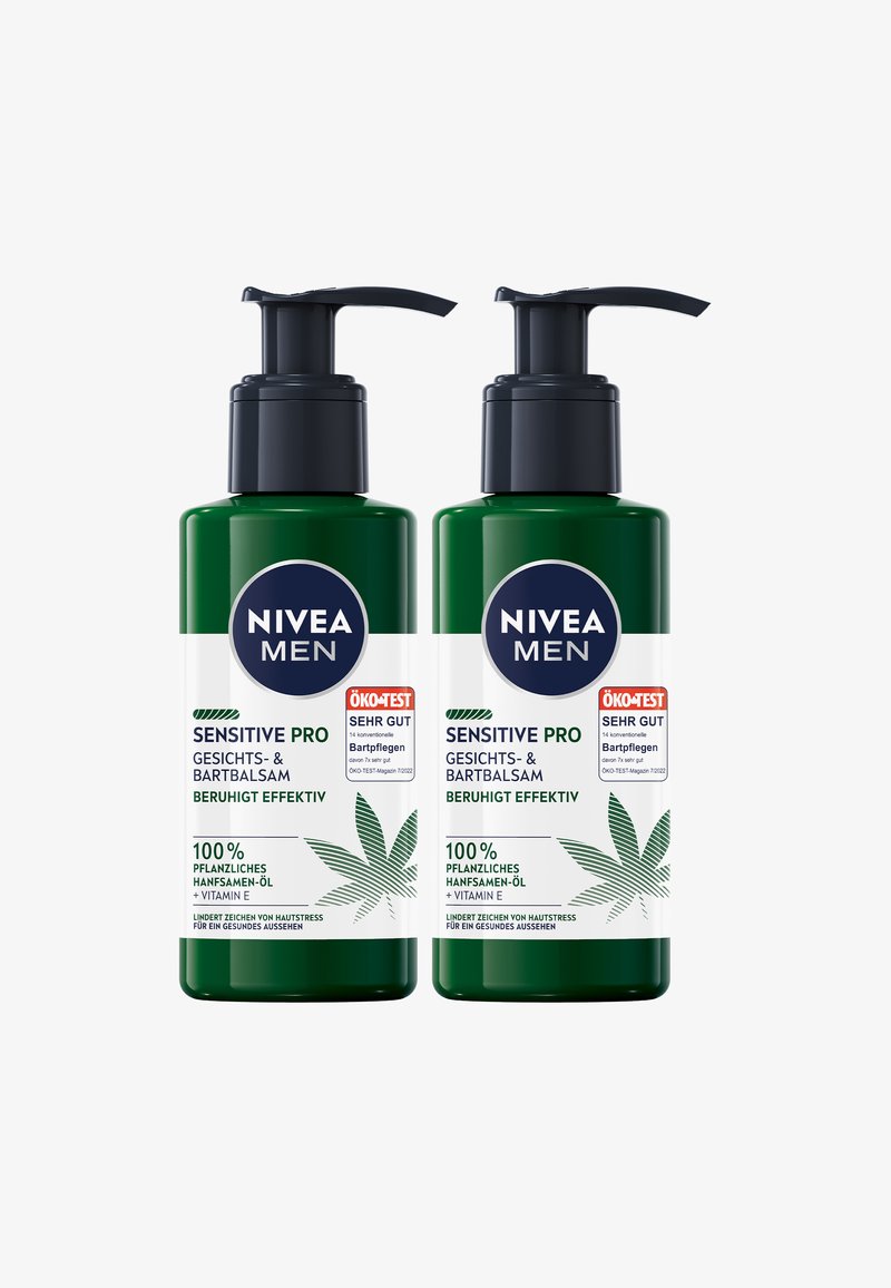 Zwei grüne Flaschen Nivea Men Sensitive Pro Gesicht- und Bartbalsam, mit Pumpkopf, weißen Etiketten und einem Blattmuster.