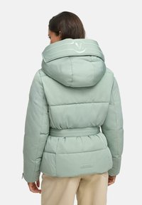 Gevoerde mintgroene jas met een hoge kraag en capuchon, voorzien van een tailleriem, geribbelde details en een subtiel logo op de achterkant.