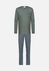 Olijfgroene V-hals top met lange mouwen en borstzak, gecombineerd met marineblauwe broek met witte verticale strepen.