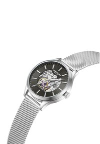 Sølv automatisk ur med mesh-armbånd, rund kasse, sort urskive og synlige indre mekanismer med farverige gear og markeringer.