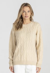 Beżowy sweter z warkoczowym splotem, okrągłym dekoltem, długimi rękawami oraz ściągaczami przy rękawach i na dole. Wykonany z miękkiego, fakturowanego materiału.