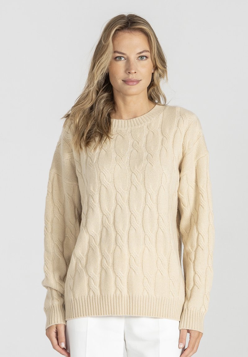 Beżowy sweter z warkoczowym splotem, okrągłym dekoltem, długimi rękawami oraz ściągaczami przy rękawach i na dole. Wykonany z miękkiego, fakturowanego materiału.