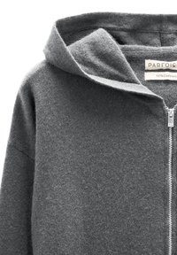 Szary kaszmirowy hoodie z zamkiem, z dużym kapturem i miękką teksturą. Metka głosi "PARFOIS 100% Kaszmir."