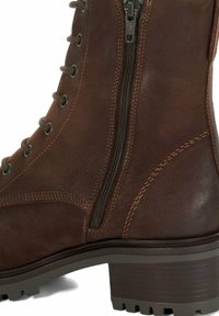Bruine leren enkelboot met een rits aan de zijkant, veters, contrasterende stiksels en een robuuste rubberen zool met een gematigde hak.