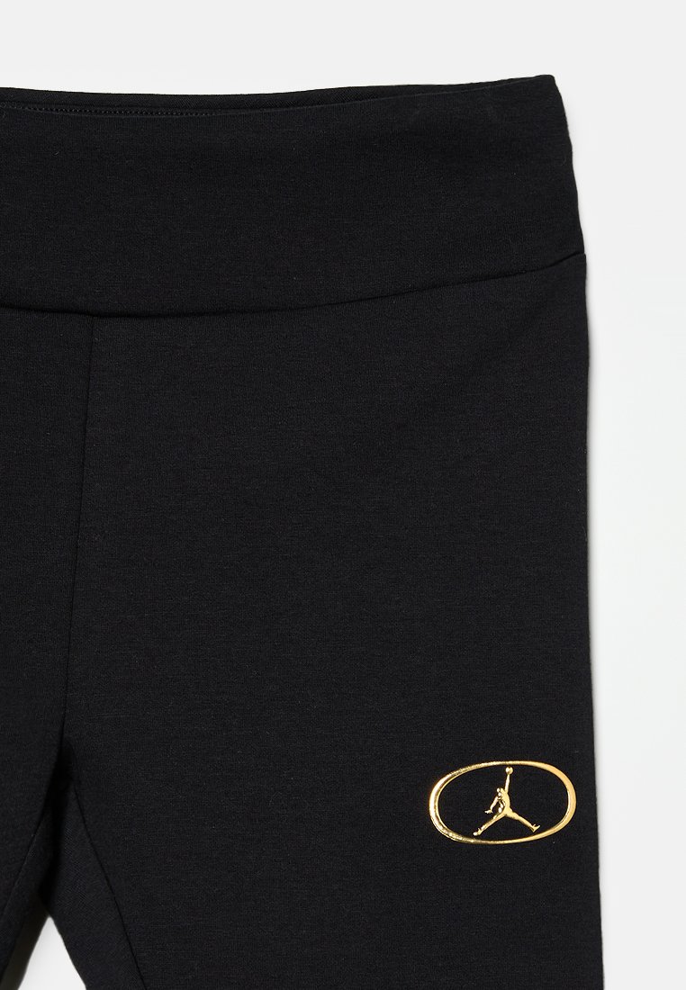 Schwarze Leggings aus Baumwollmischung mit einem breiten Bund und einem goldenen, bestickten Air Jordan-Logo auf der unteren linken Seite.
