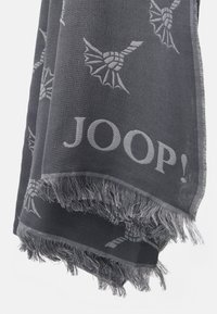 Bufanda gris con un patrón tejido de motivos abstractos y el logo "JOOP!" a lo largo del borde, con detalles de flecos en un lado.