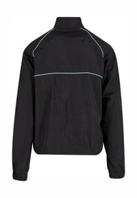 Veste légère noire avec un col haut, présentant des coutures contrastantes en bleu clair le long des épaules et du dos. Manches longues avec des poignets élastiques.