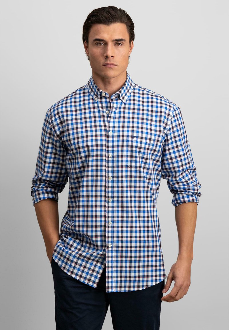 Blauw-wit geruite overhemdd met opgerolde mouwen, voorzien van een borstzakje en een button-down kraag. Vlotte stoftextuur.