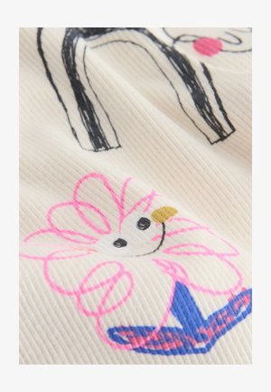 Fehér szövet bordázott textúrával, amelyen fekete vonalrajz egy kutyát ábrázol, valamint rózsaszín és kék virágminta látható fekete és sárga középponttal.