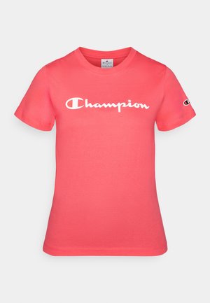 Camiseta de manga corta en coral brillante, hecha de algodón, con el logo blanco de "Champion" en el pecho y un emblema en la manga.