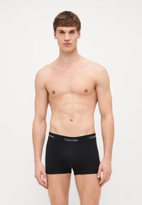 Μαύρα boxer briefs με μαλακή, ελαστική μέση που φέρει το λογότυπο της Calvin Klein. Το ύφασμα φαίνεται λείο και εφαρμοστό.