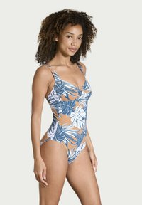 Einteiliger Badeanzug mit floralen Mustern, der weiße und marineblaue Blätter auf einem braunen Hintergrund zeigt, entworfen mit dünnen Trägern.