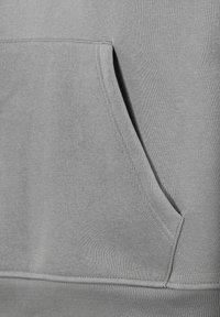 Grauer Sweatshirtstoff mit Kängurutasche, geripptem Saum und glatter Textur sowie doppelter Nahtverarbeitung entlang der Nähte.