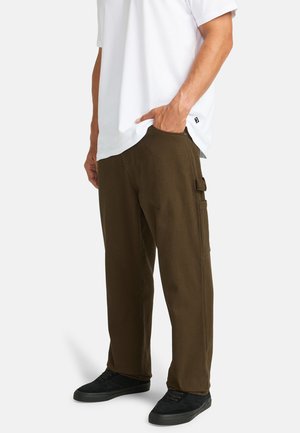 Brown cargo pants with a straight fit, featuring a side pocket and a smooth texture, paired with a white t-shirt and black sneakers.