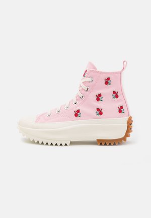 Hoog-top roze canvas sneakers met bloemenborduursels, een witte rubberen zool met gekartelde randen, en een textuur bruin accent op de hiel.