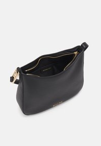 Sort læder skuldertaske med guldfarvet hardware, lynlåslukning og en glat tekstur. Indersiden har et label og rigelig plads.